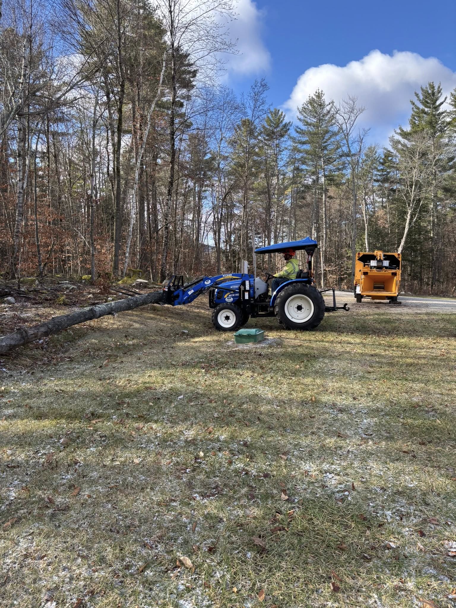 Tree service tractor hauling logs at job site in Vermont